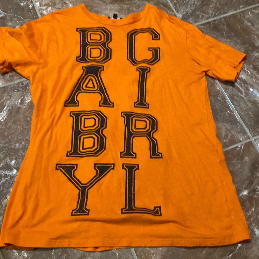 An orange Fashion Nova babygirl shirt.